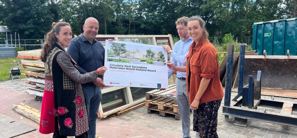 Medewerkers Omring en Van Wijnen staand voor geoogste bouwmaterialen