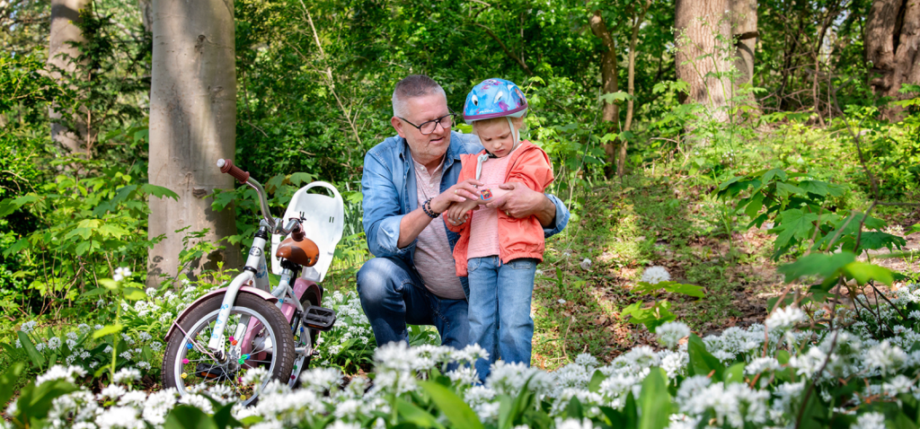 Campagnebeeld van Omring thuiszorg: opa die een pleister plakt op de wond van zijn kleinzoon.