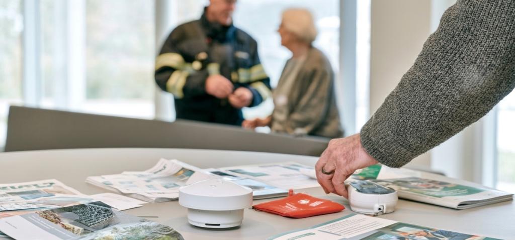 Mevrouw in gesprek met een brandweerman.