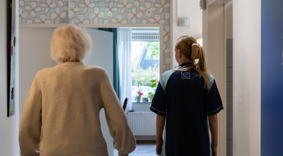 Mevrouw Doves loopt met medewerker door Buitenveld