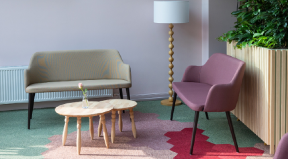 Zithoek in de gemeenschappelijke ruimte van woonlocatie Betsy Perk met fauteuils, tafeltjes en planten.