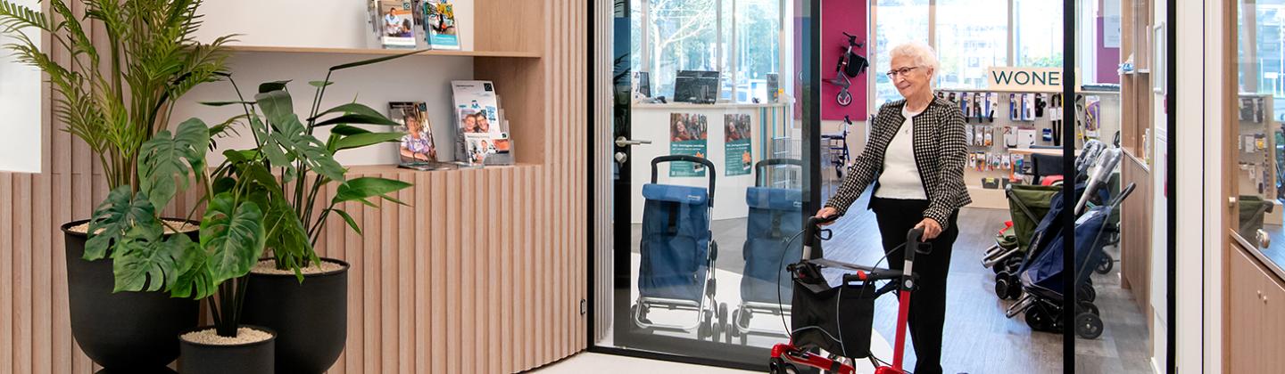Mevrouw loopt uit de Omringwinkel (Thuiszorgwinkel) in Hoorn met een nieuwe rollator.