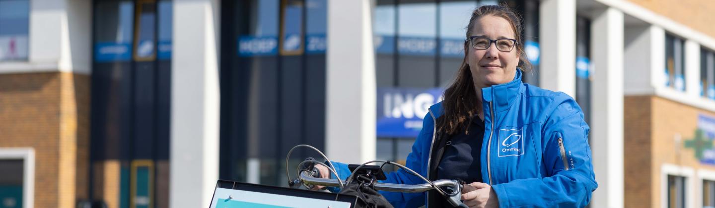 Medewerker van het Omring thuiszorgteam staat voor gezondheidscentrum Zuiderweg.