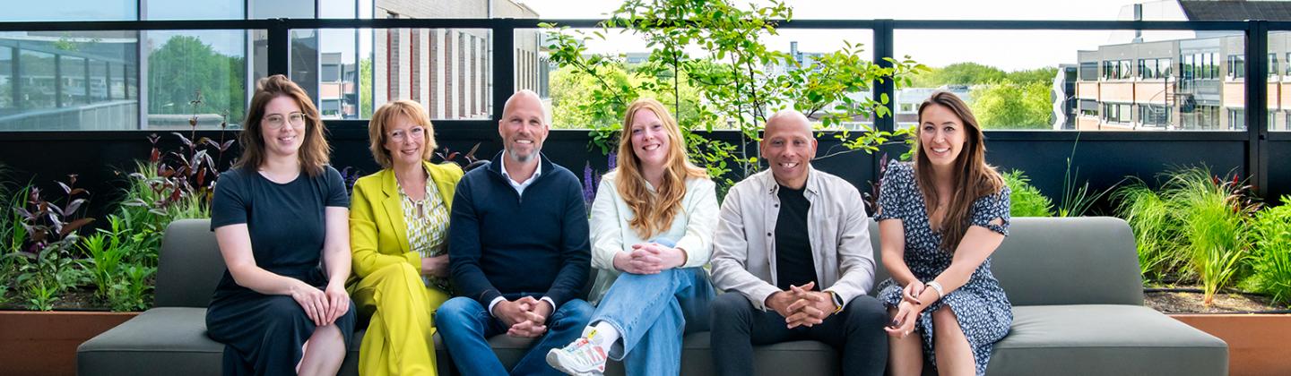 Foto van 6 leden van een MVO projectteam, naast elkaar op een bank.
