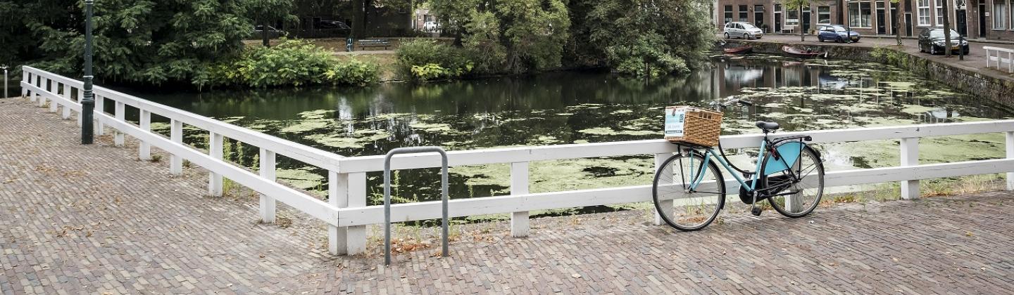 Fiets van Omring staat in de binnenstad van Hoorn aan de gracht geparkeerd.
