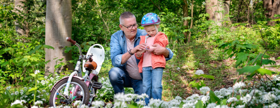Campagnebeeld van Omring thuiszorg: opa die een pleister plakt op de wond van zijn kleinzoon.