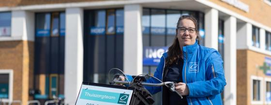 Medewerker van het Omring thuiszorgteam staat voor gezondheidscentrum Zuiderweg.