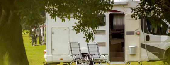 Een camper met twee kampeerstoelen