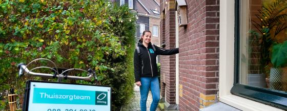Een medewerker van thuiszorgteam Bovenkarspel belt aan bij een woning.