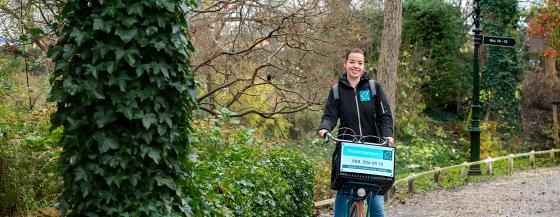 De wijkverpleegkundige fietst door het Snouck van Loosenpark in Enkhuizen.