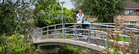 Verpleegkundige van Omring thuiszorg fietst door Hoogkarspel.
