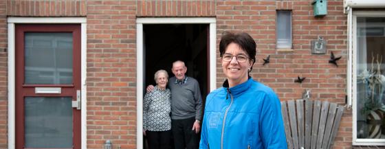 Een verpleegkundige van Omring thuiszorg staat voor de deur bij een echtpaar.