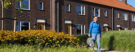 Medewerker van thuiszorgteam Wieringermeer is op weg naar een cliënt en wandelt door de wijk.