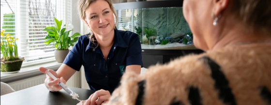 Verpleegkundig specialist dient plasmedicatie via een infuus toe bij patiënt thuis