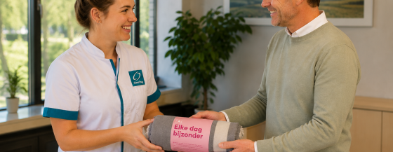 Afbeelding van een zorgmedewerker van Omring die een cadeau overhandigd krijgt van een manager (door AI gegenereerd).