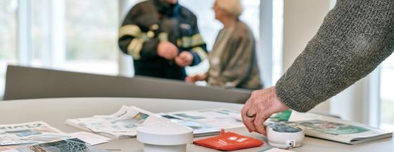 Mevrouw in gesprek met een brandweerman.